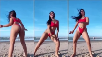 Francielly Araujo bailando en bikini en una playa llena de gente